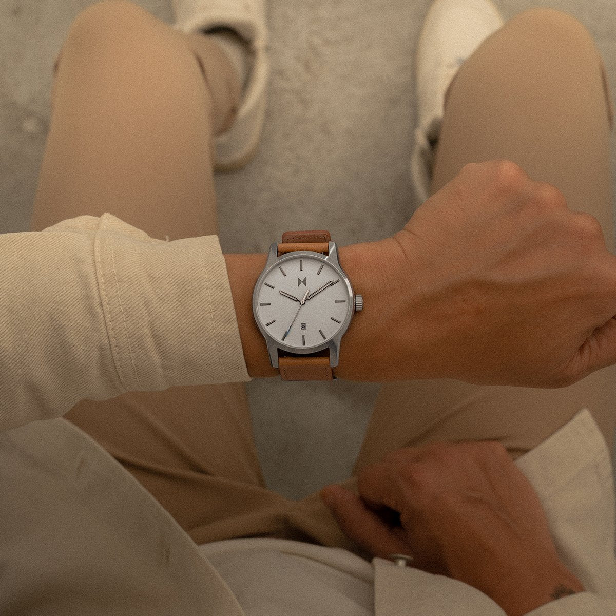 Man in tan clothes wearing the Classic II watch with brown suede strap and white dial.