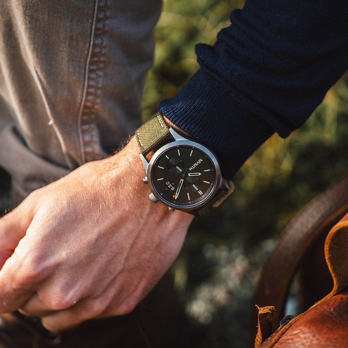 Man in a blue sweater and jeans wearing the Havoc men's green strap chronograph watch
