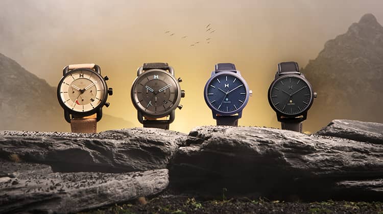 Four solar watches sitting on a rock.