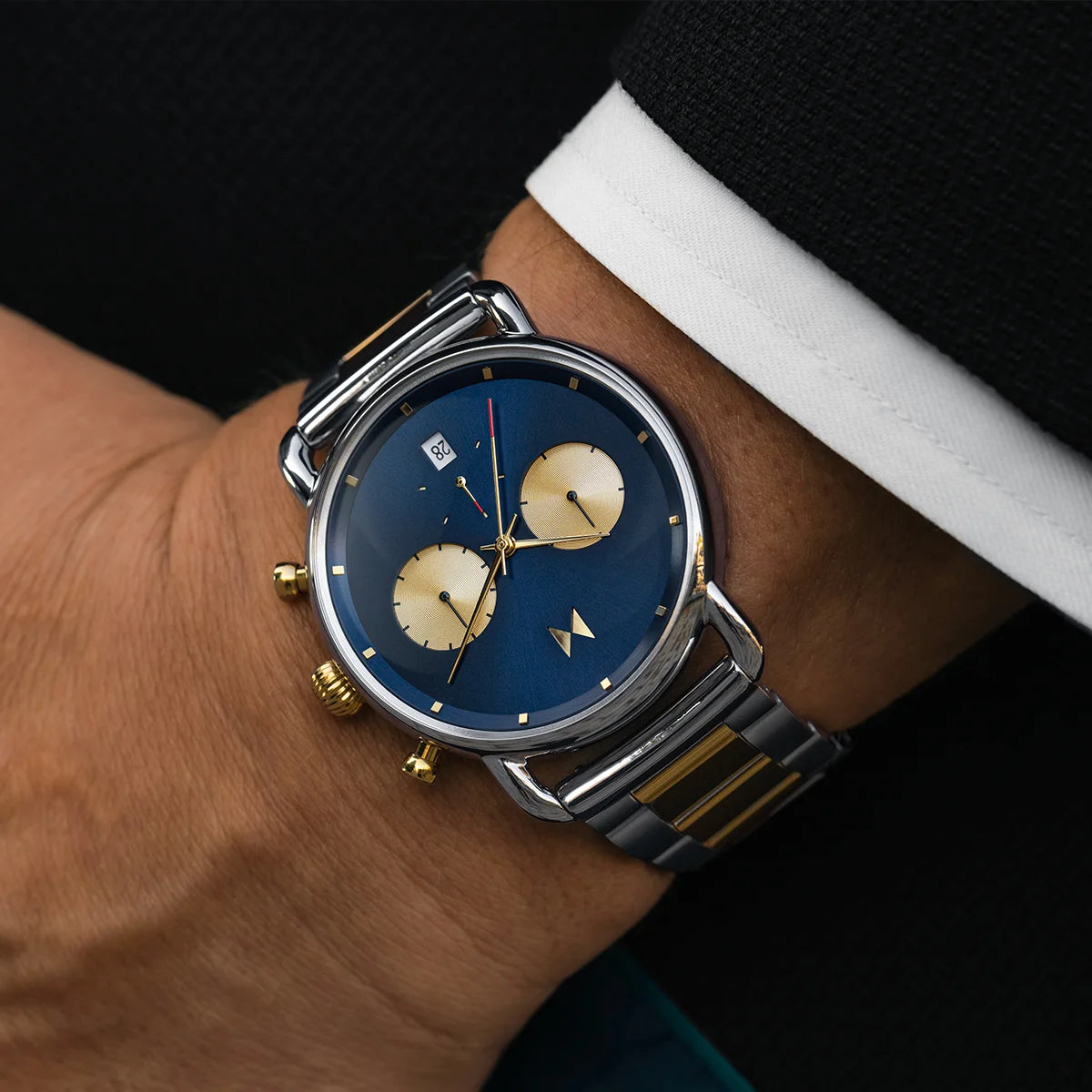 Man wearing the Blacktop II watch with stainless steel bracelet and blue dial with two gold sub dials.