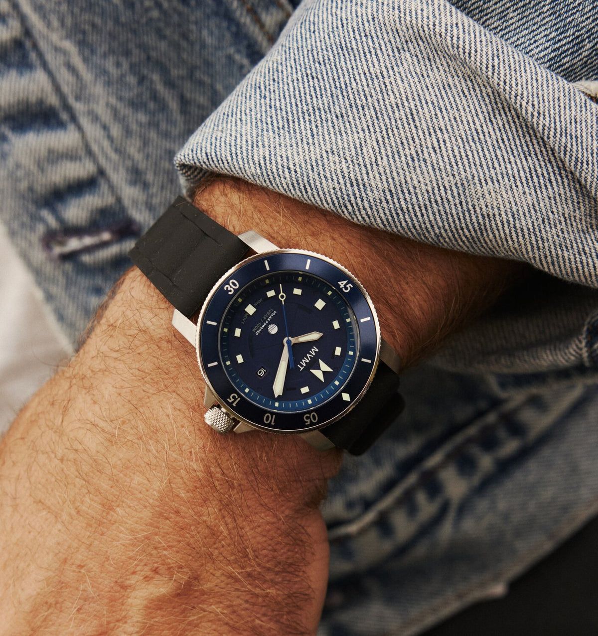 Man in a denim jacket wearing the Cali Diver Solar watch with black strap and blue dial.