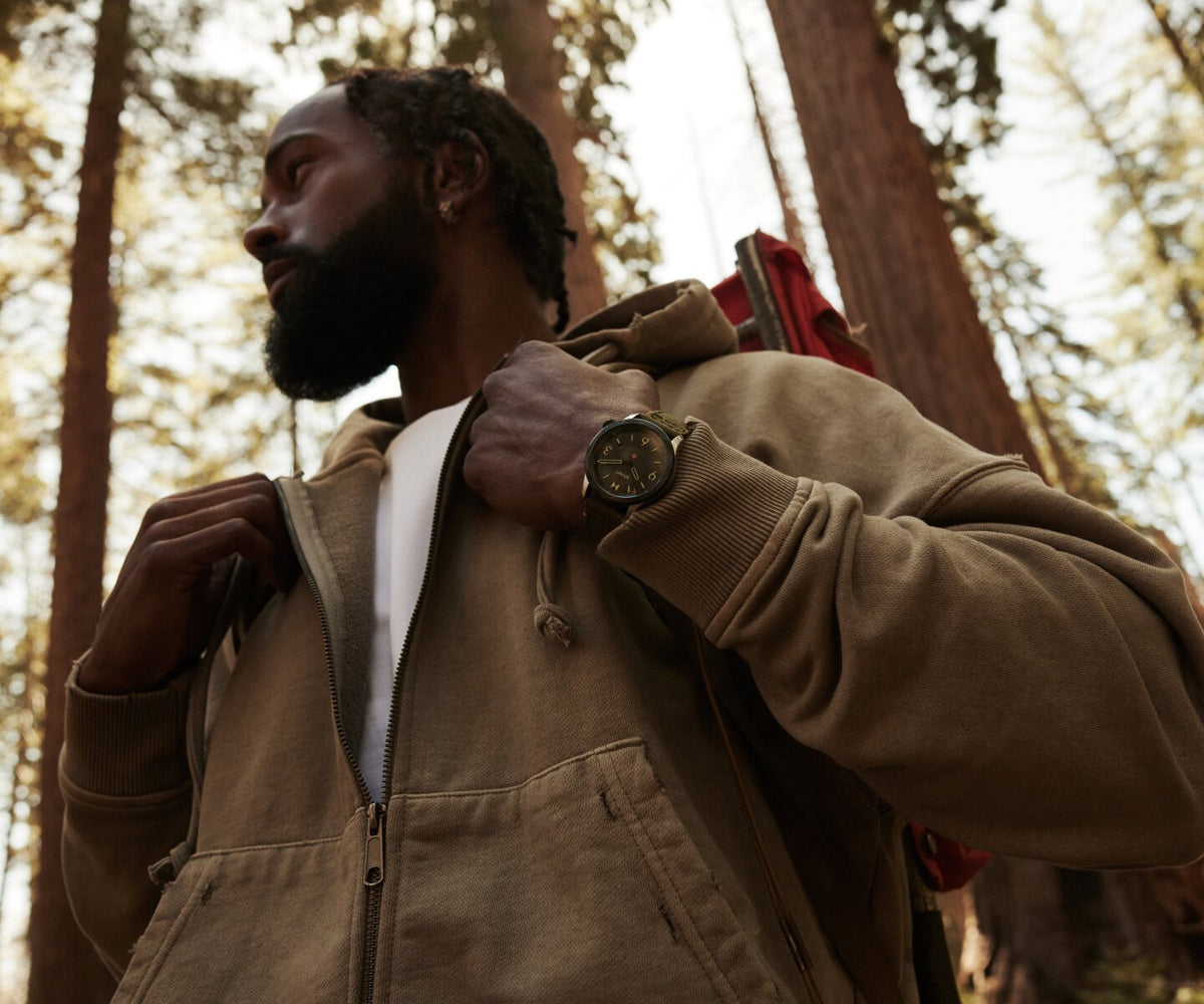 Man in a sweater and backpack wearing the men's Field II solar watch